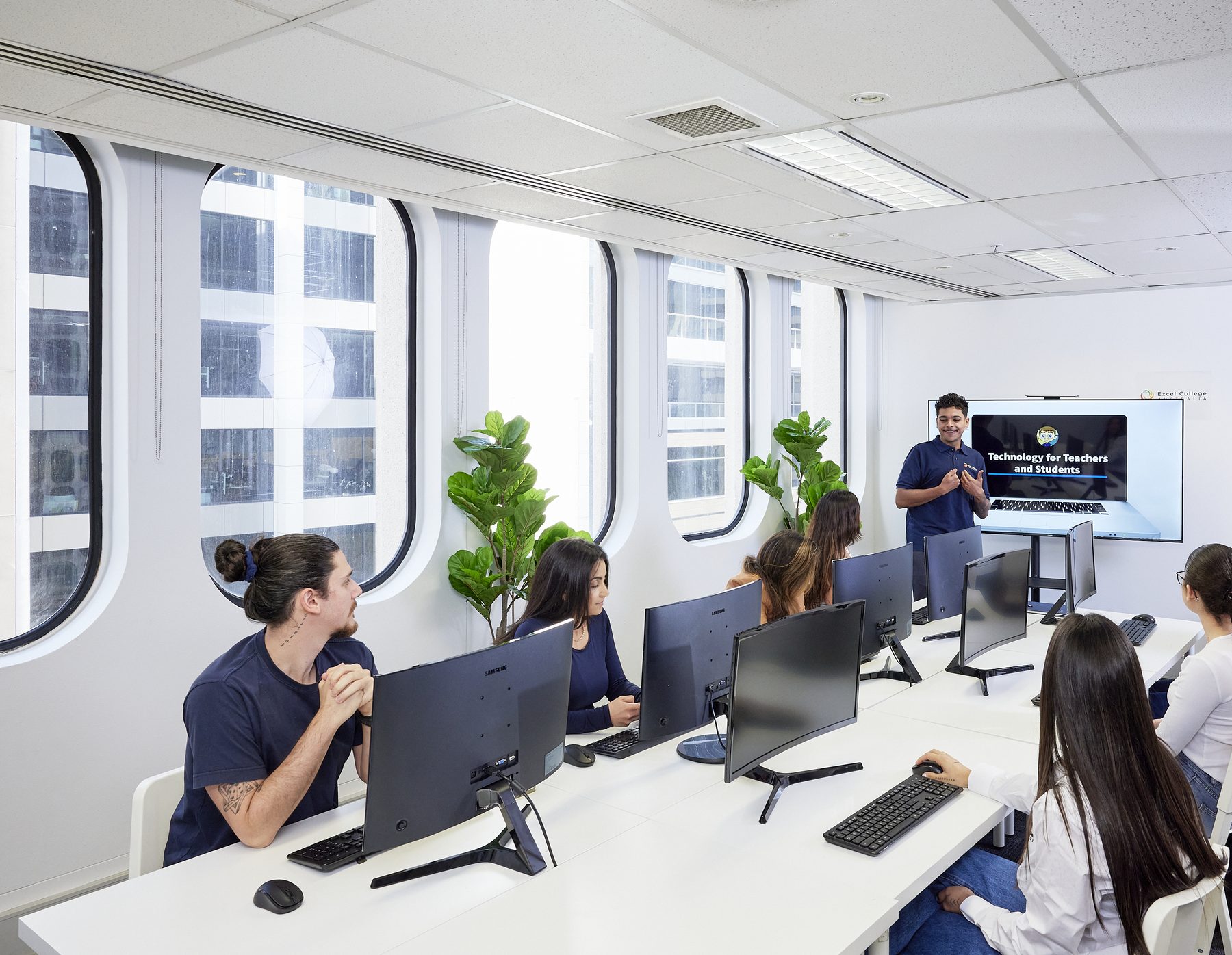 Students learning with a trainer in a computer lab